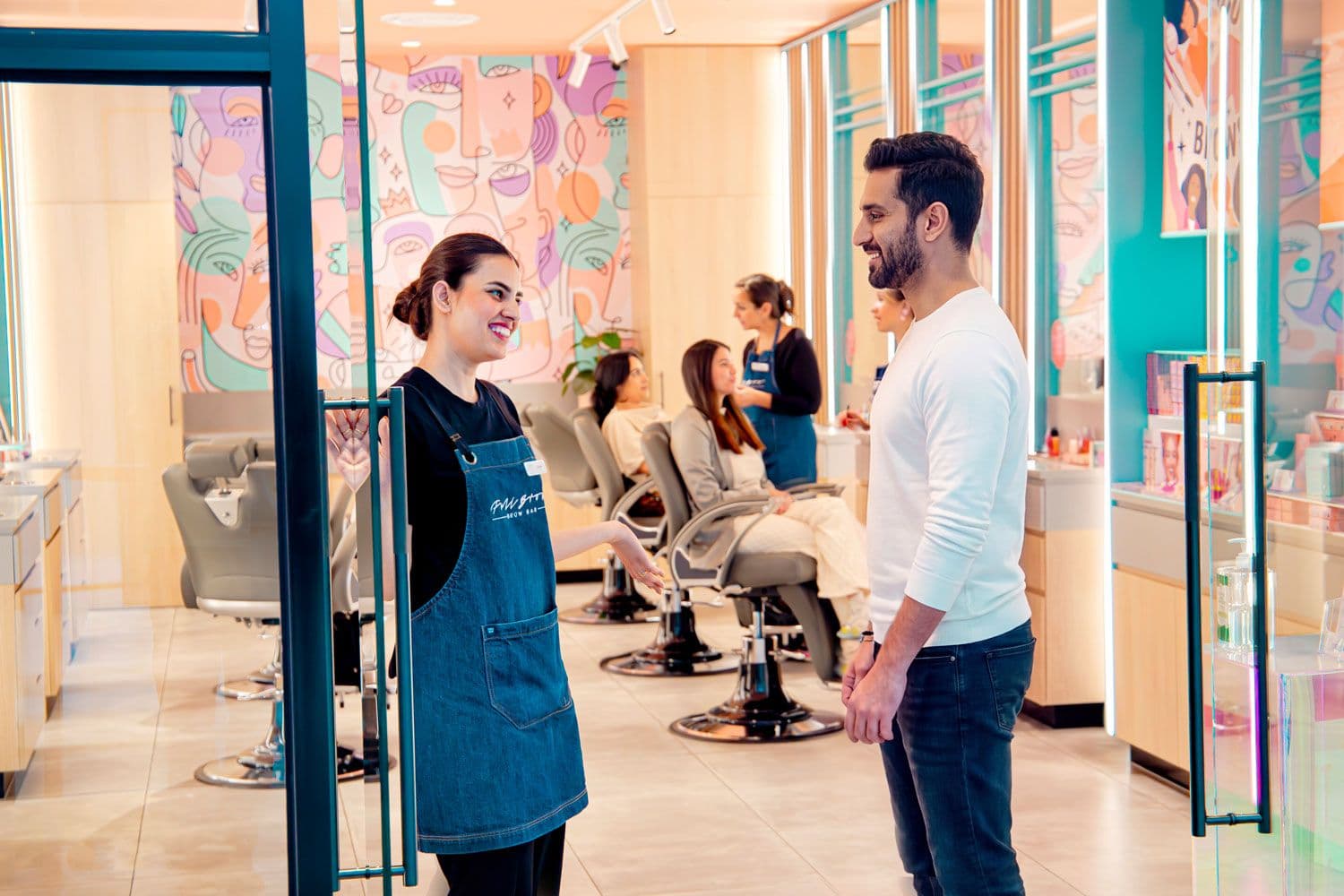 Full Brow Bar stylist chatting with a male customer in the studio
